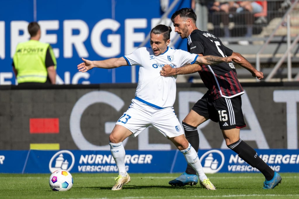 Magdeburgs Baris Atik (l) wird von Nürnbergs Ivan Marquez attackiert.