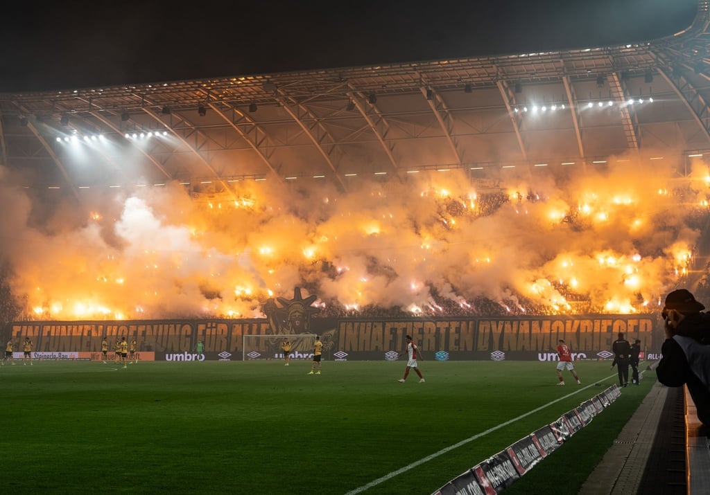 Dynamos Fans im K-Block zünden Bengalos und zeigen Banner „Ein Funken Hoffnung für alle inhaftierten Dynamokrieger“.