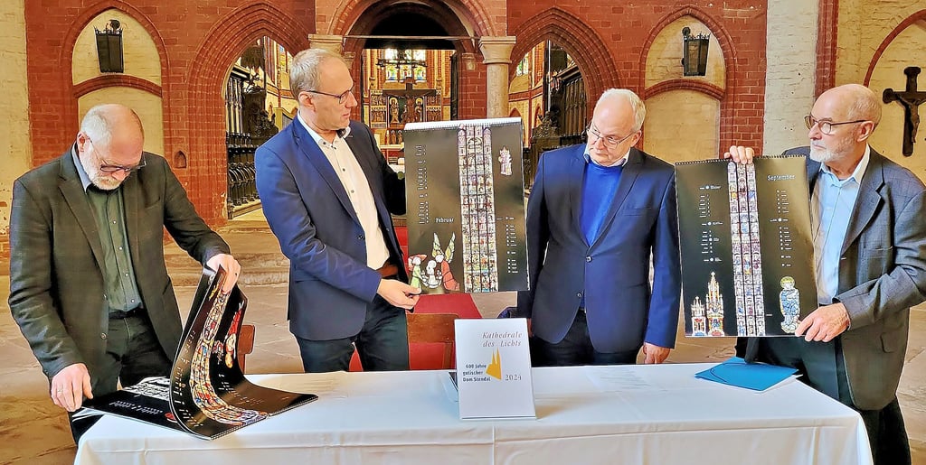 Detlef Frobel (von links), Vorsitzender des Gemeindekirchenrates, Dompfarrer Markus Schütte, OB-Stellvertreter Axel Kleefeldt und Joachim Franke, Vorsitzender des Dom-Förderkreises, präsentieren den Kalender für das Dom-Festjahr 2024 in Stendal.