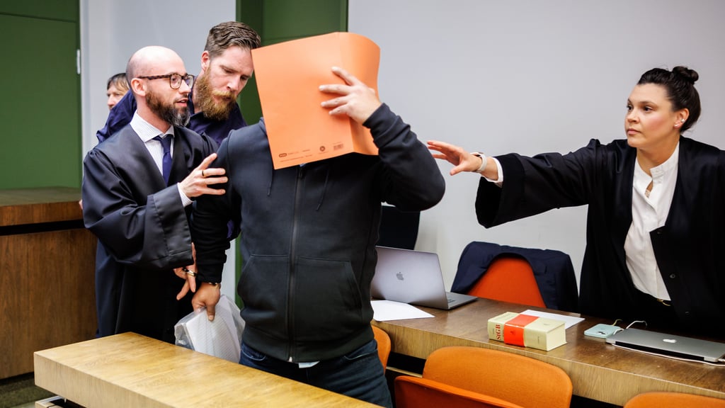 Der Angeklagte (M) wird zu Prozessbeginn neben seinen Anwälten Francesca Rossiello-Bianco (r) und Deniz Aydin (l) in einen Gerichtssaal vom Landgericht München II geführt.
