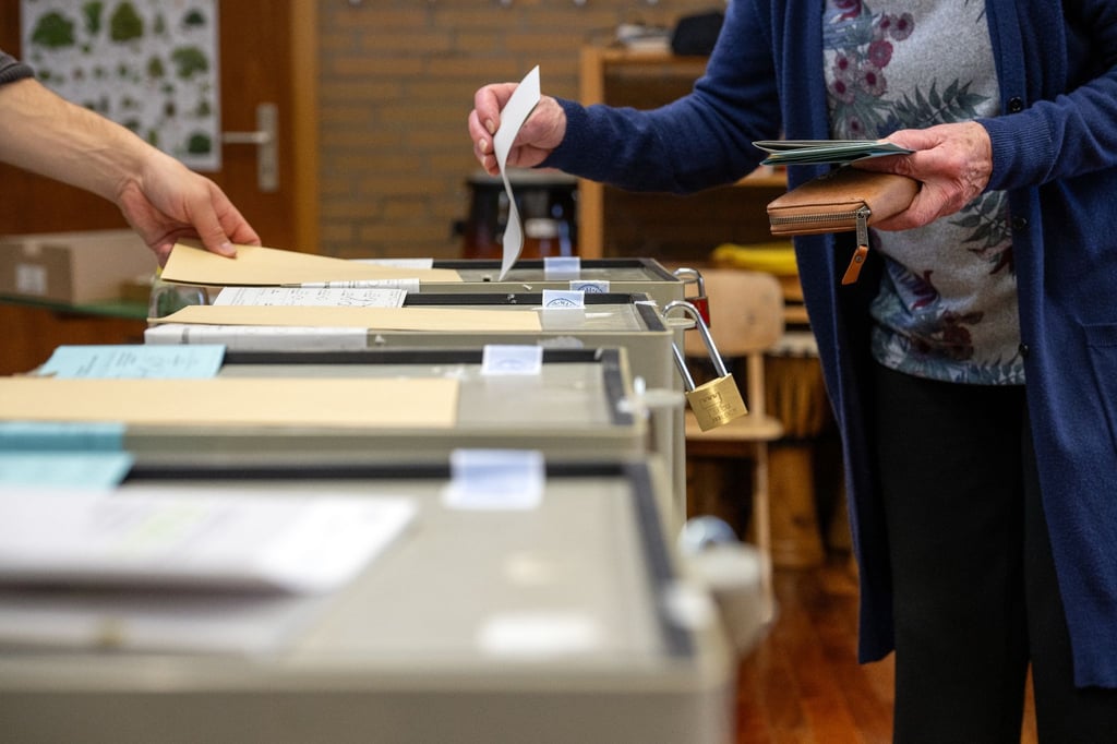 Ein Frau wirft ihren Stimmzettel in die Wahlurne.