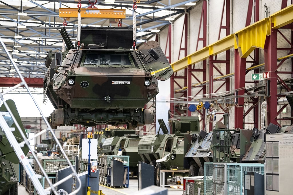 Ein Panzer vom Typ Fuchs schwebt in der Fertigungshalle von Rheinmetall.