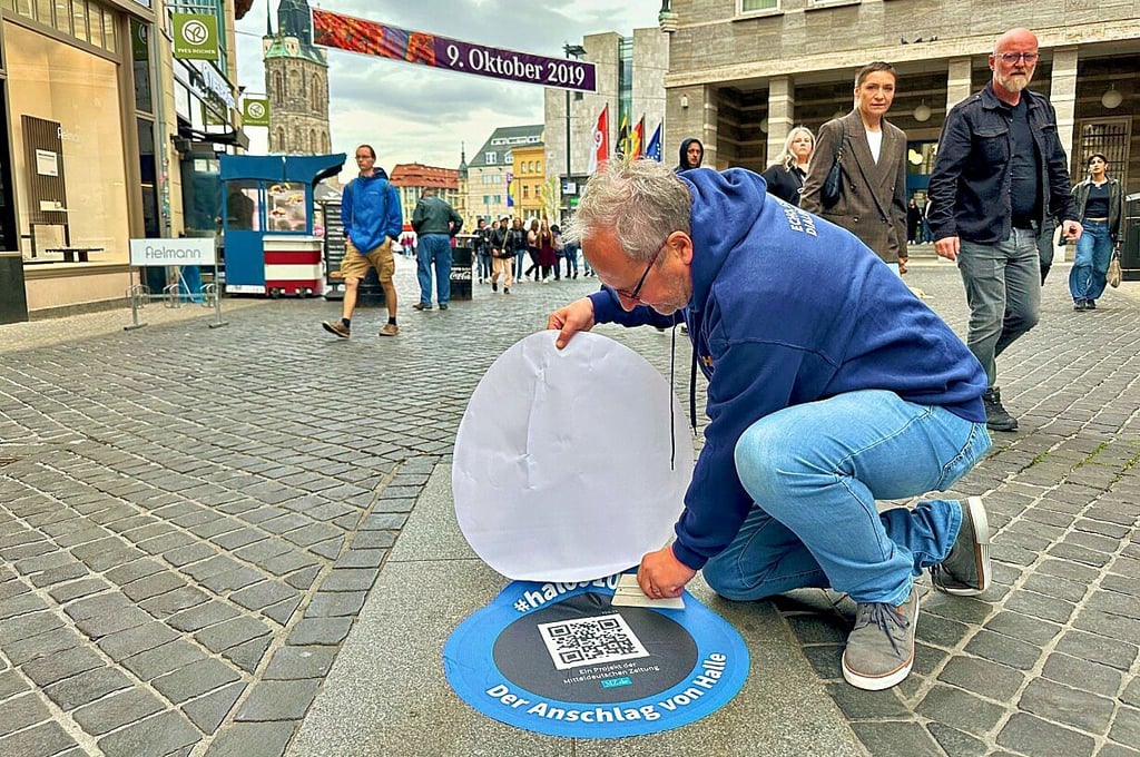 MZ-Chefredakteur Marc Rath platzierte den letzten Bodenaufkleber der MZ-Serie zum 9. Oktober auf dem unteren Boulevard kurz vor dem Markt.