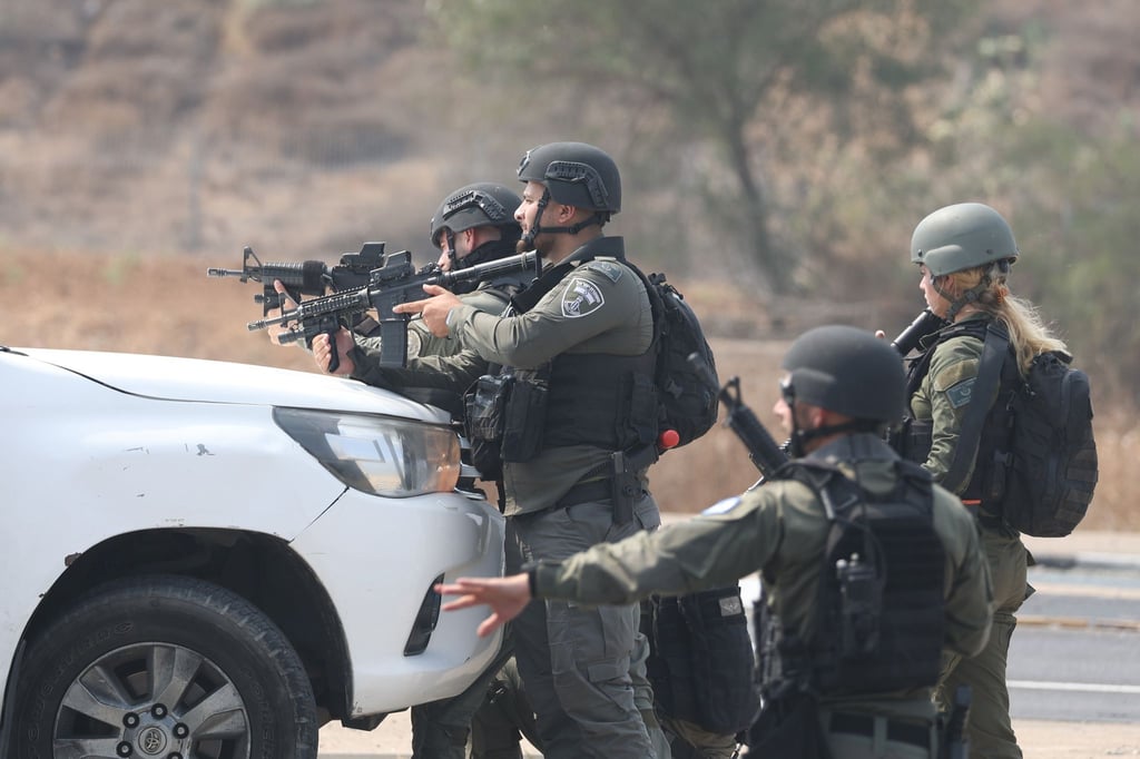 Israelische Streitkräfte gehen hinter einem Fahrzeug in Sderot in Stellung.