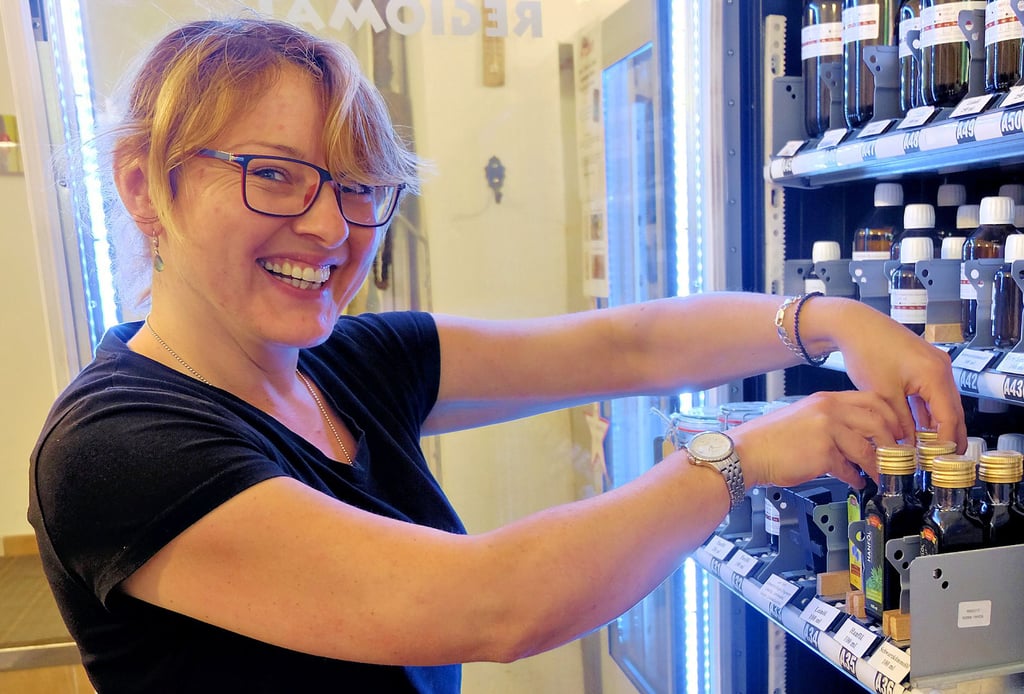  Chefin Nadine Eiserbeck befüllt  den Ölautomaten mit neuen Flaschen.  Hier kann der Kunde  auch Senf und  Seifen kaufen. 