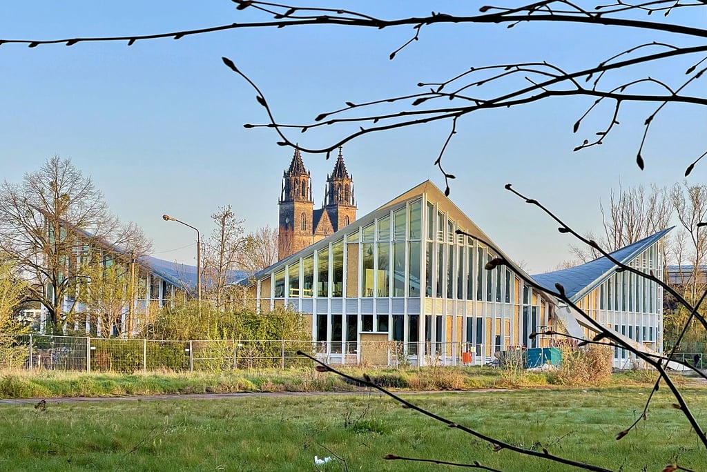 Zwei Wahrzeichen der Stadt vereint: Die Hyparschale wird derzeit unter dem wachsamen Blick des Doms saniert. Die für 2024 angedachte Freiflächengestaltung soll verschoben werden. Grund ist die finanzielle Misere Magdeburgs.
