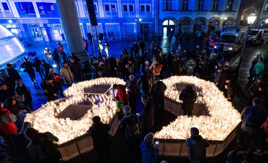 Bürgerinnen und Bürger gestalten im Hof der Nikolaikirche in Lepzig eine 89 aus Kerzen.