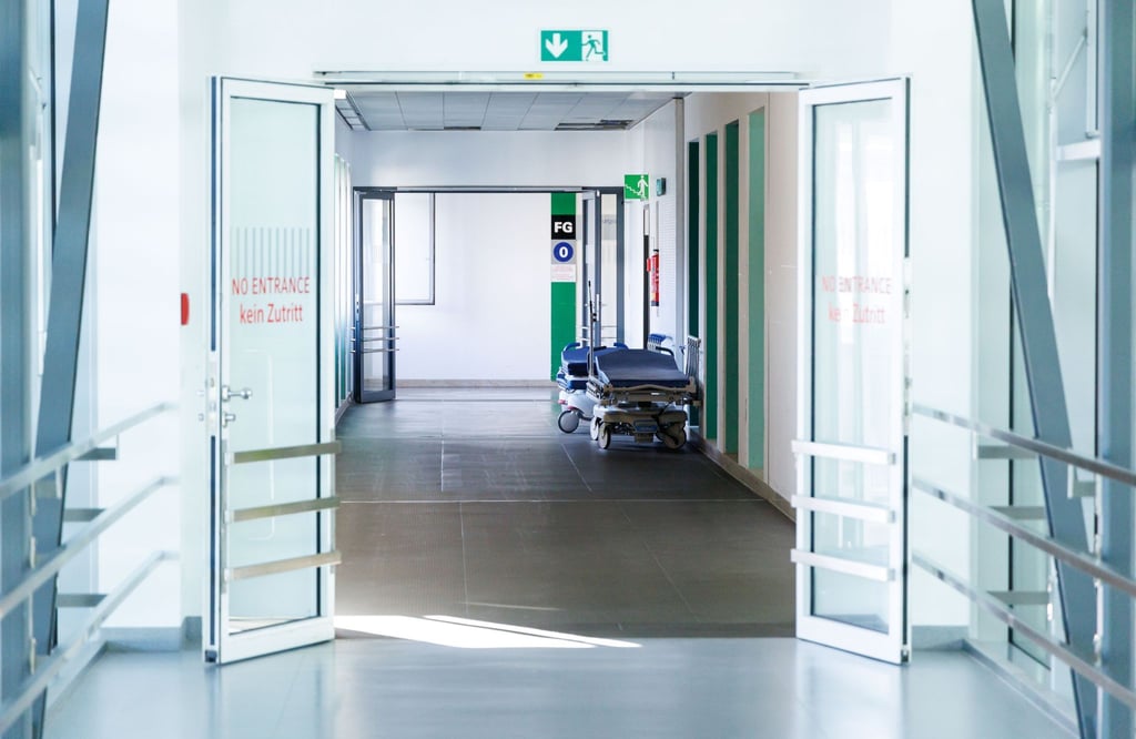 Krankenbetten stehen in einem Gang in einem Krankenhaus.