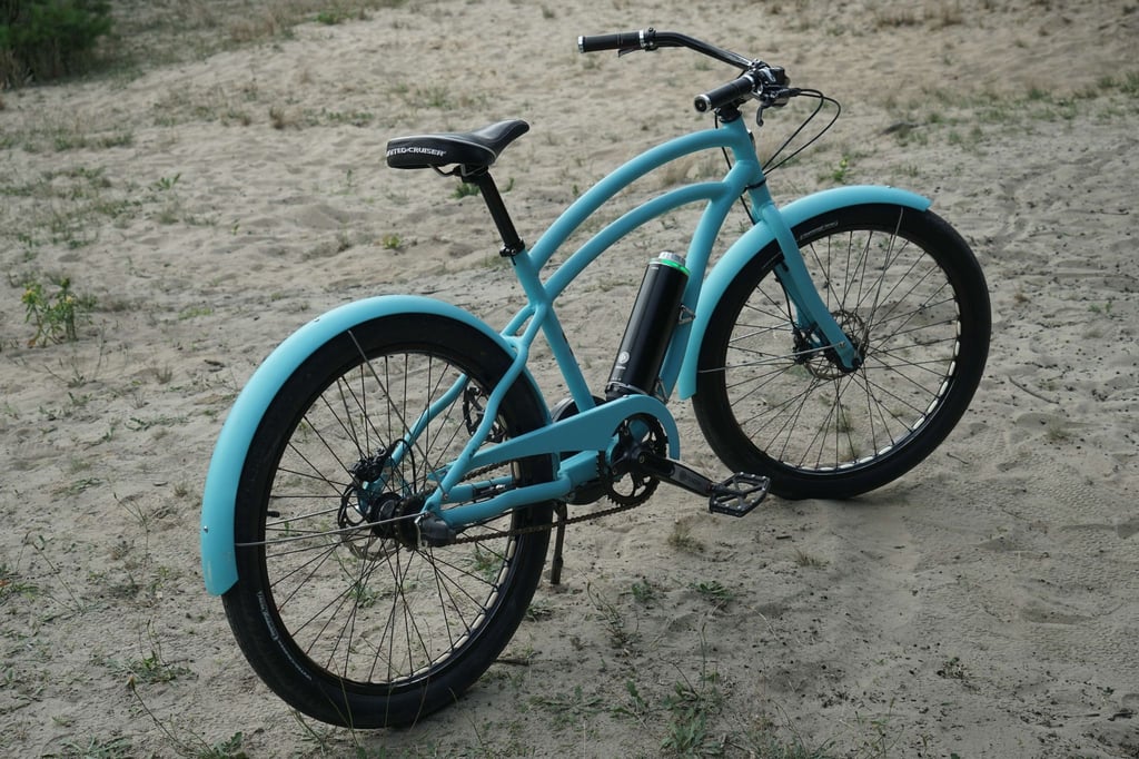Geschwungene Rohre, ein breiter Sattel und der raumgreifende Lenker zählen zu den Kernmerkmalen von Cruiser Bikes. Die hellblaue Rahmenfarbe geht wie der ganze Fahrradtyp als sommerlich durch.