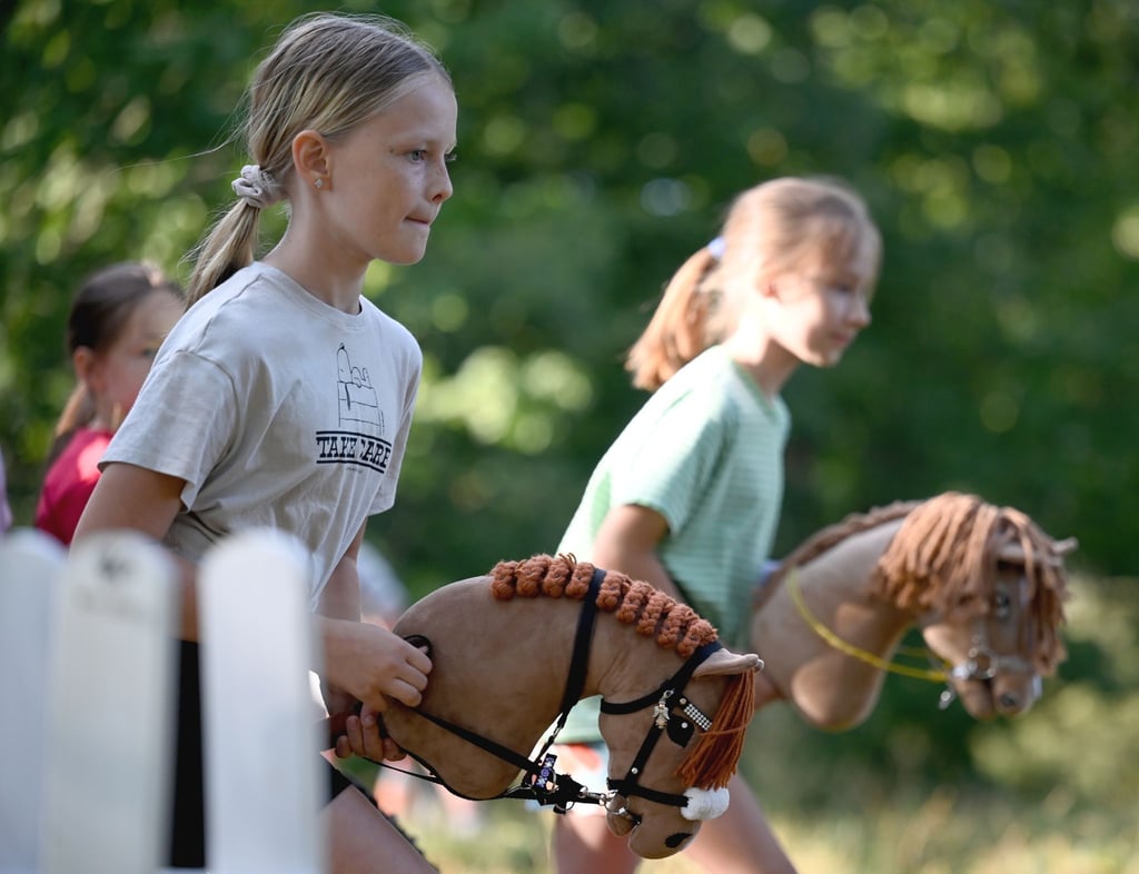 Zwei Mädchen beim Hobby Horsing-Kurs im Berliner Volkspark Wuhlheide.