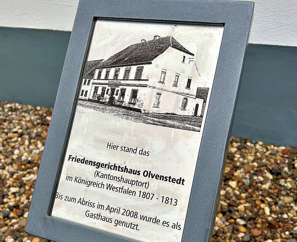 Die Erinnerungstafel zeigt das ehemalige Friedensgerichtshaus, gegenüber dem ehemaligen Rathaus. 