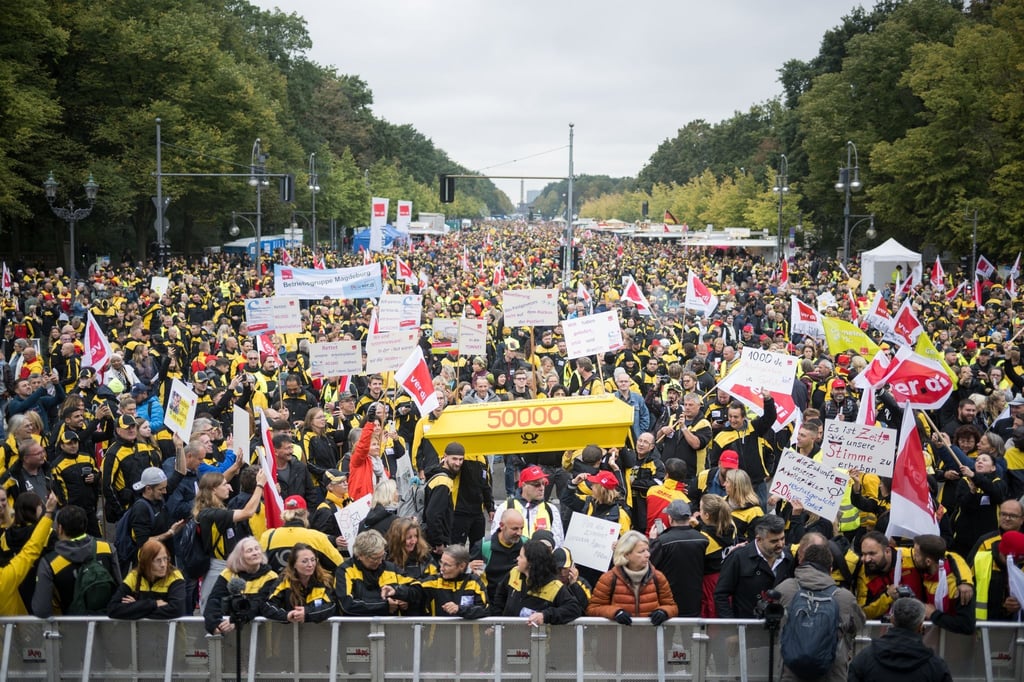 Postmitarbeiter stehen während einer Verdi-Großkundgebung zur Novelle des Postgesetzes auf der Straße des 17. Juni.