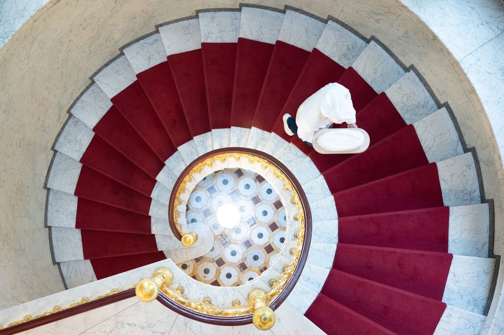Andreas Wippler, Bäckermeister, trägt einen Stollen auf einer Wendeltreppe.
