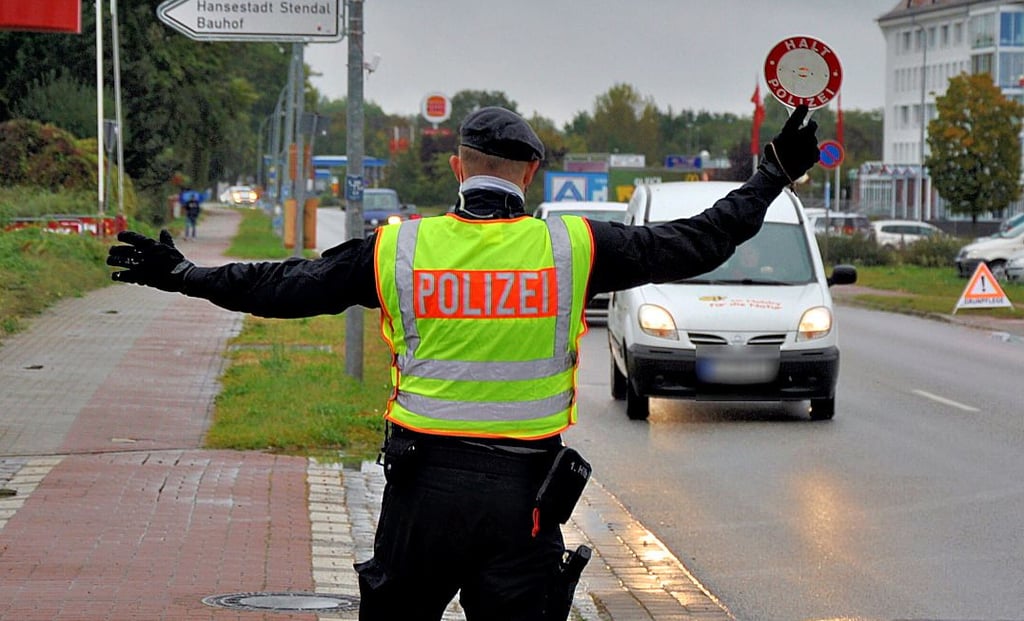 Ein Polizeibeamter winkt in der Arneburger Straße in Stendal einen Autofahrer aus dem Verkehr.