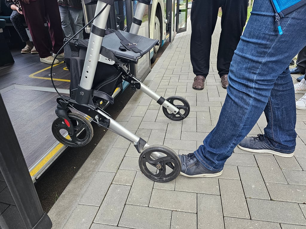 Manuela Schäfer zeigt den Senioren, wie man mit einem Rollator richtig in einem Bus einsteigt, wenn die Haltestelle nicht barrierefrei ist.