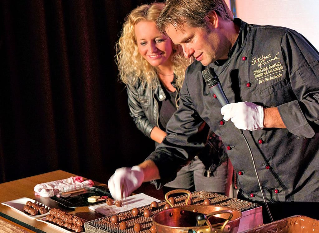 Christina Rommel und der Chocolatier während eines Konzerts in der Schokoladenküche auf der Bühne in Aktion.