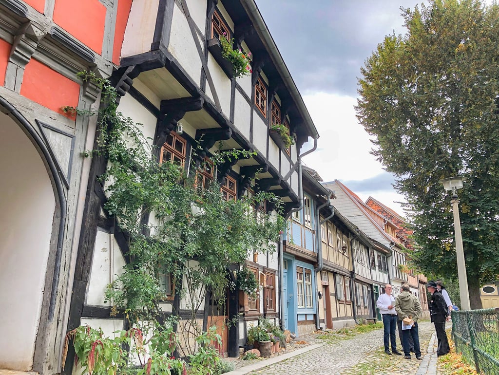 Peter Deutschbein begrüßt an der Sanierung beteiligte Handwerker vor seinem Haus Neustädter Kirchhof 7, das mit dunkel gestrichenem Fachwerk und hellen Putzflächen sein historisches Antlitz wiedererhalten hat.