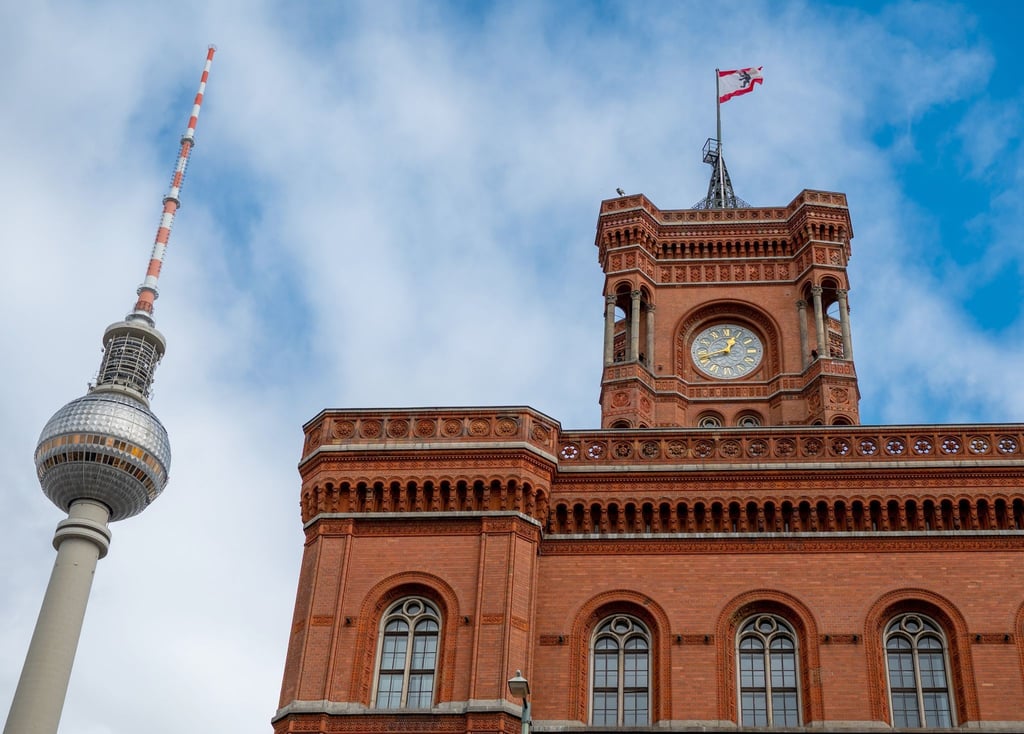 Blick auf den Fernsehturm und das Rote Rathaus mit einer Fahne mit Berliner Wappen.