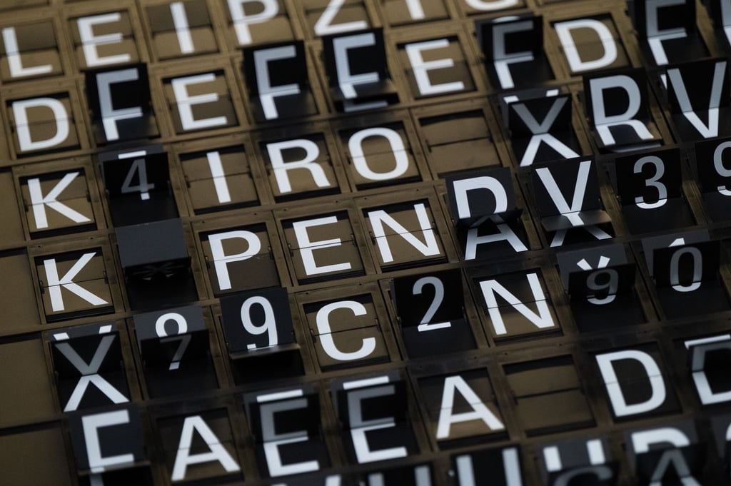 Eine Anzeigetafel an einem Flughafen stellt ihre Buchstaben um.