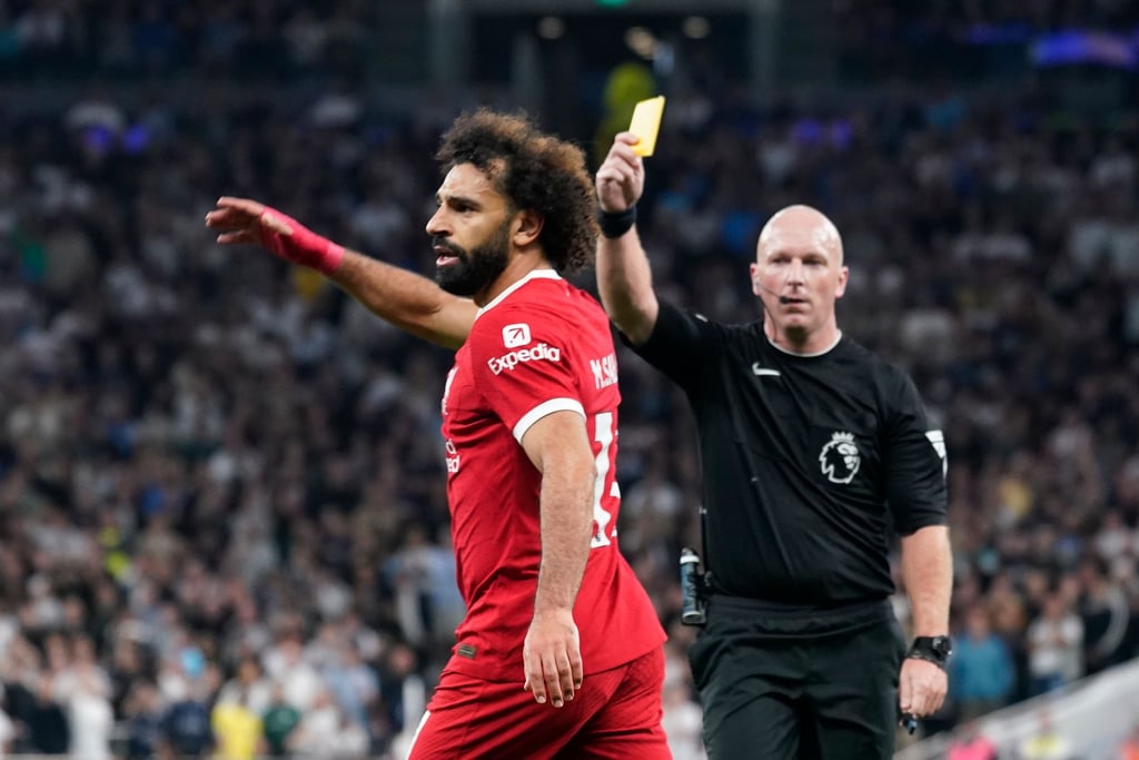 Schiedsrichter Simon Hooper (r) zeigt Mohamed Salah vom FC Liverpool die gelbe Karte.