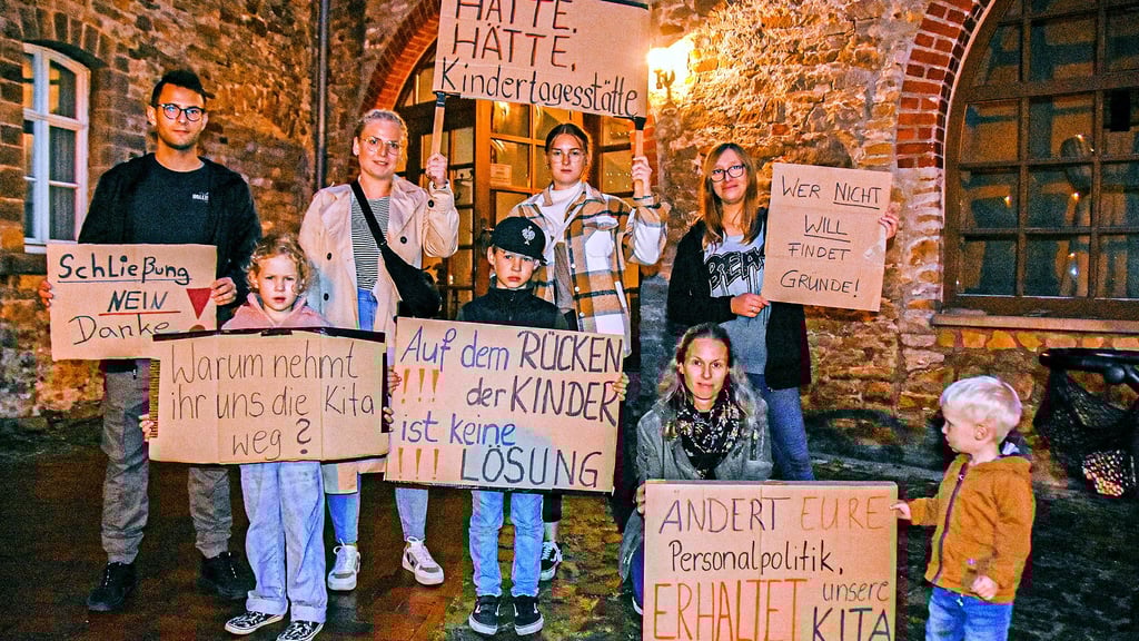 Familien aus Etingen protestieren vor der Oebisfelder Burg gegen die Schließung der Kindertagesstätte „Mühlenstrolche“ in Etingen. Auf den Plakaten ist zu lesen: „Warum nehmt ihr uns die Kita weg?“ und „Auf dem Rücken der Kinder ist keine Lösung“.