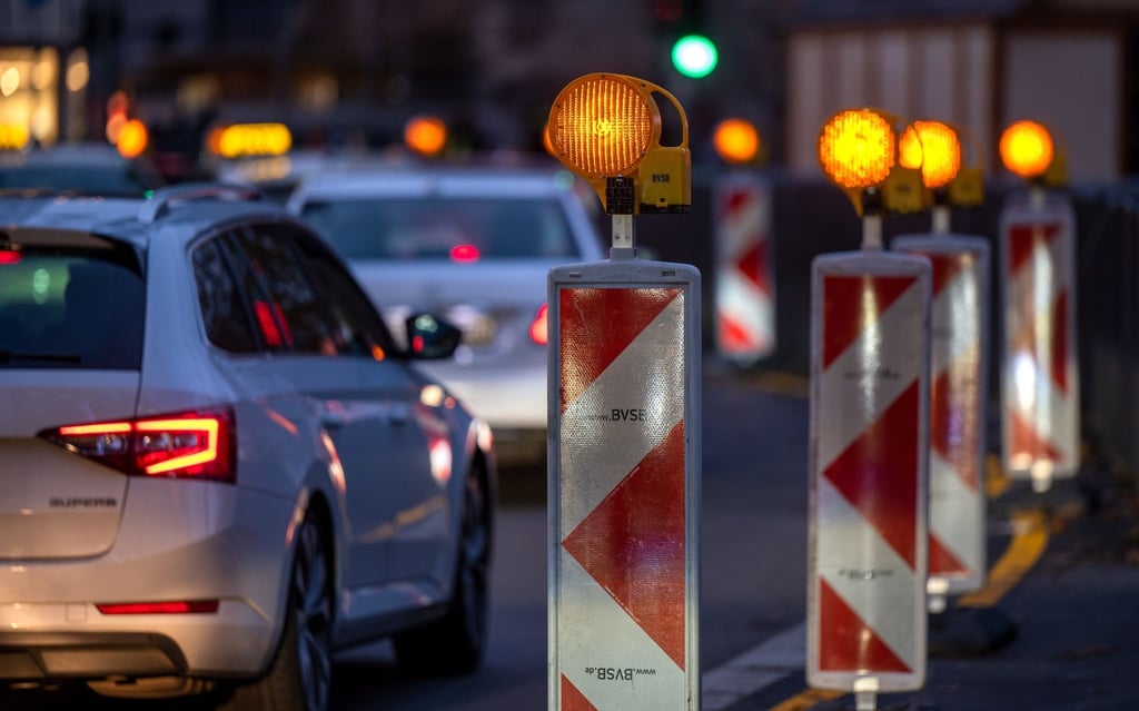 Autos stehen am Abend im Stau an einer Baustelle.