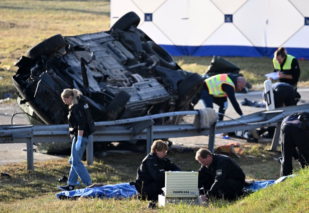 Rettungskräfte und Polizisten am umgestürzten Fahrzeug. Beim Unfall sind sieben Menschen gestorben und mehrere schwer verletzt worden.