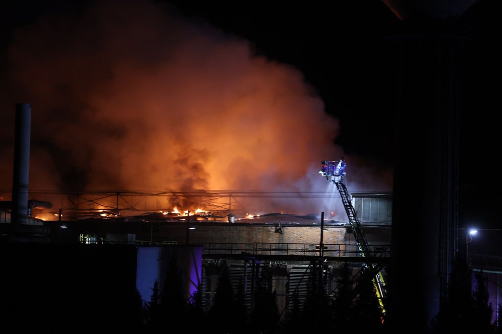 Feuerwehrleute löschen einen Brand in einer Gießerei.