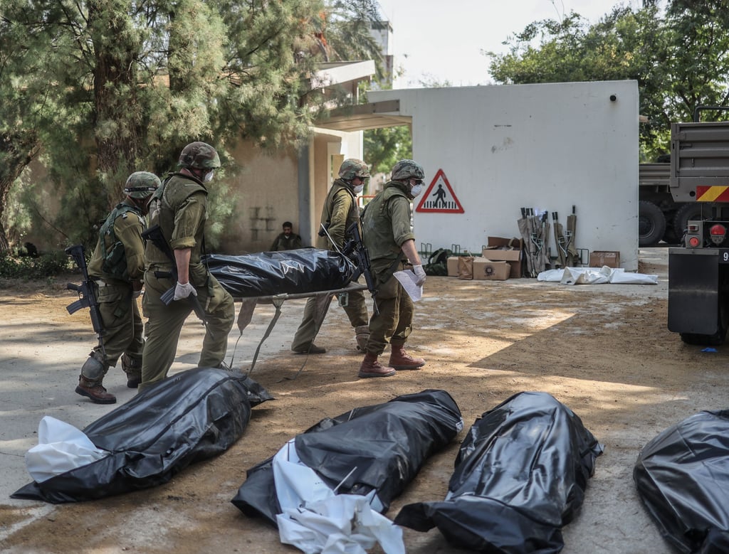 Streitkräfte bergen die Leichen israelischer Bewohner aus einem zerstörten Haus in Kfar Aza.