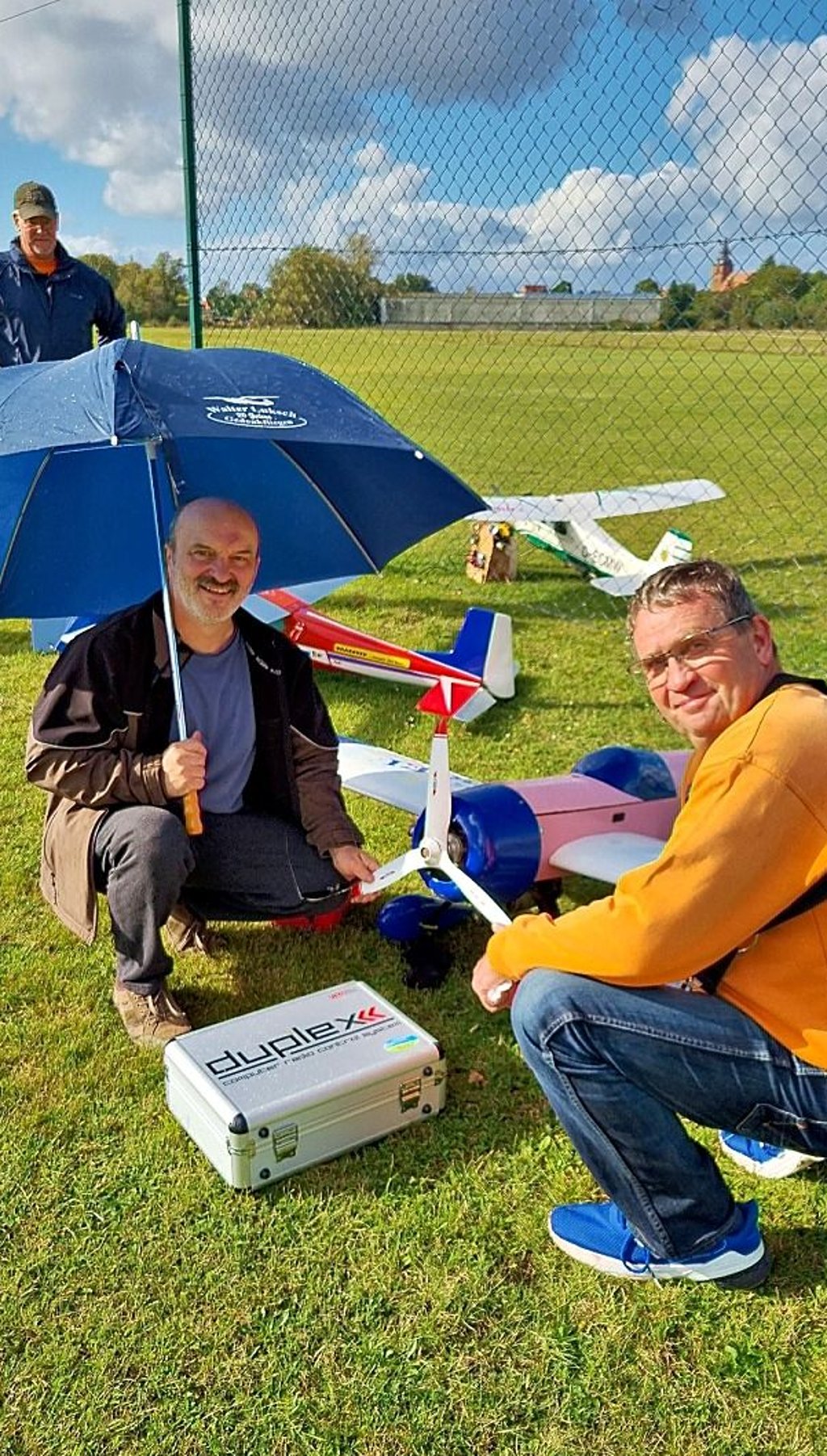 Sonne und Regen beim Vorbereiten der Modellflugzeuge. Arno Luksch und Uwe Mech wissen sich zu helfen.