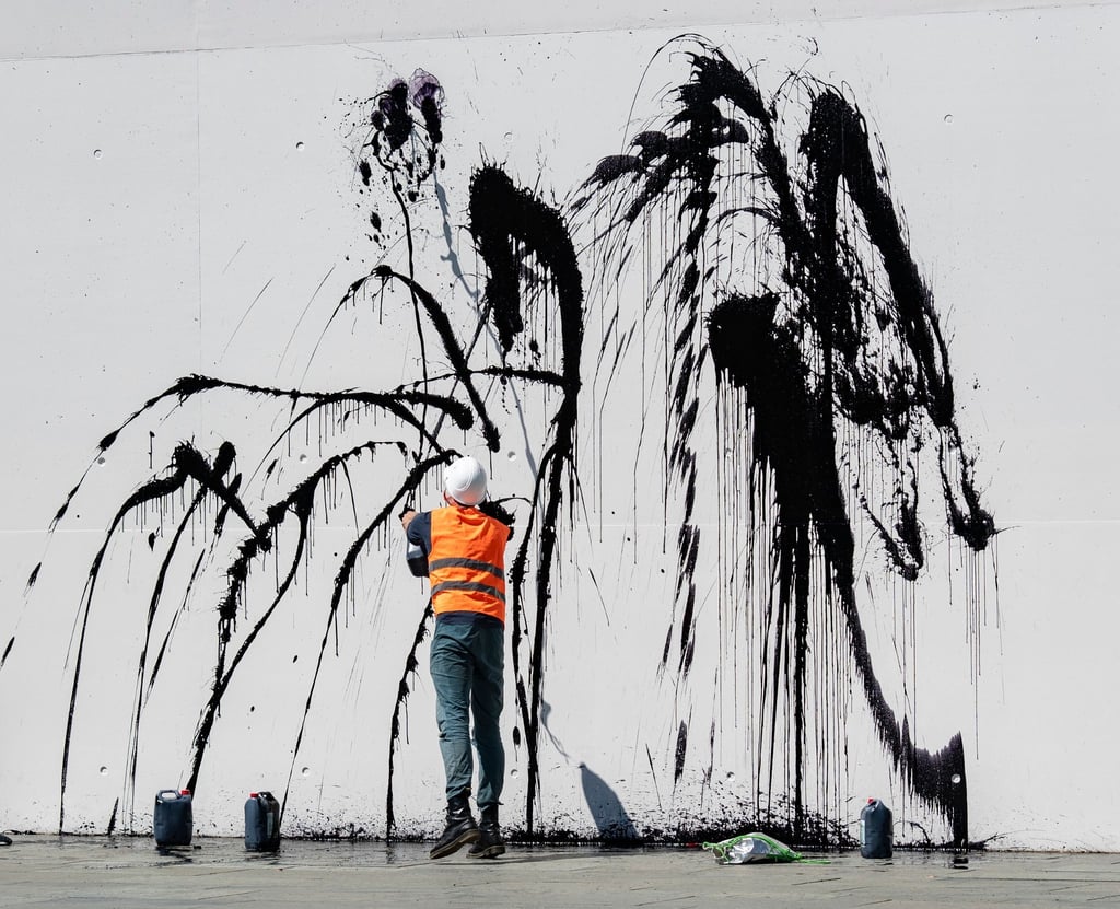 Klimaschutz-Demonstranten spritzen eine Flüssigkeit auf eine Fassade.