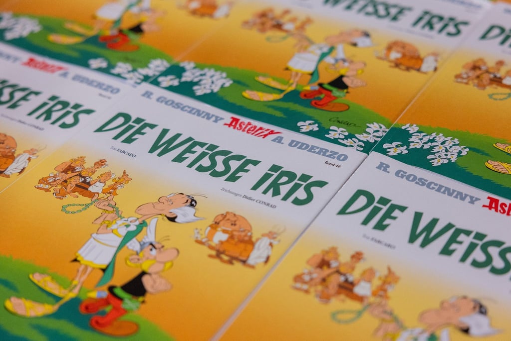 Ausgaben des neuen Asterix-Bandes mit dem Titel „Die weiße Iris“ werden in einer Logistikhalle konfektioniert und in Displays für den Einzelhandel verpackt.