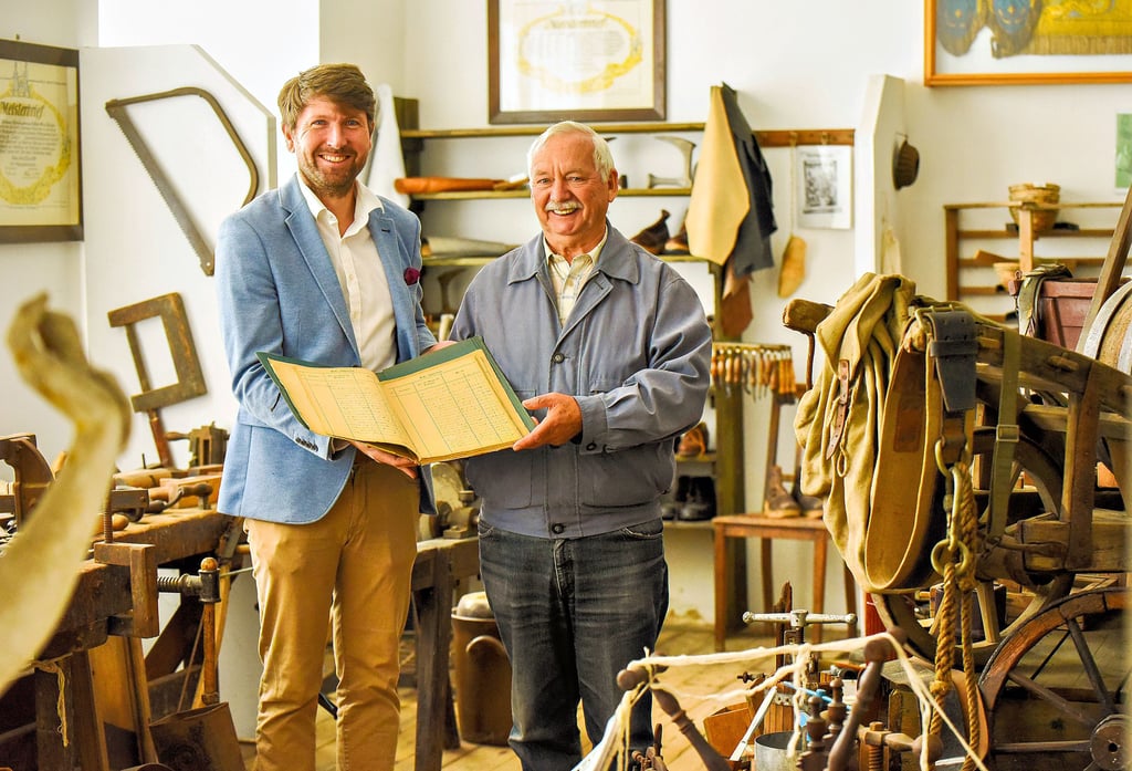 Marc Poppe (l.) und Anreas Arms stehen mit einem alten Grundbuch in der Bauernstube des Heimatmuseums.