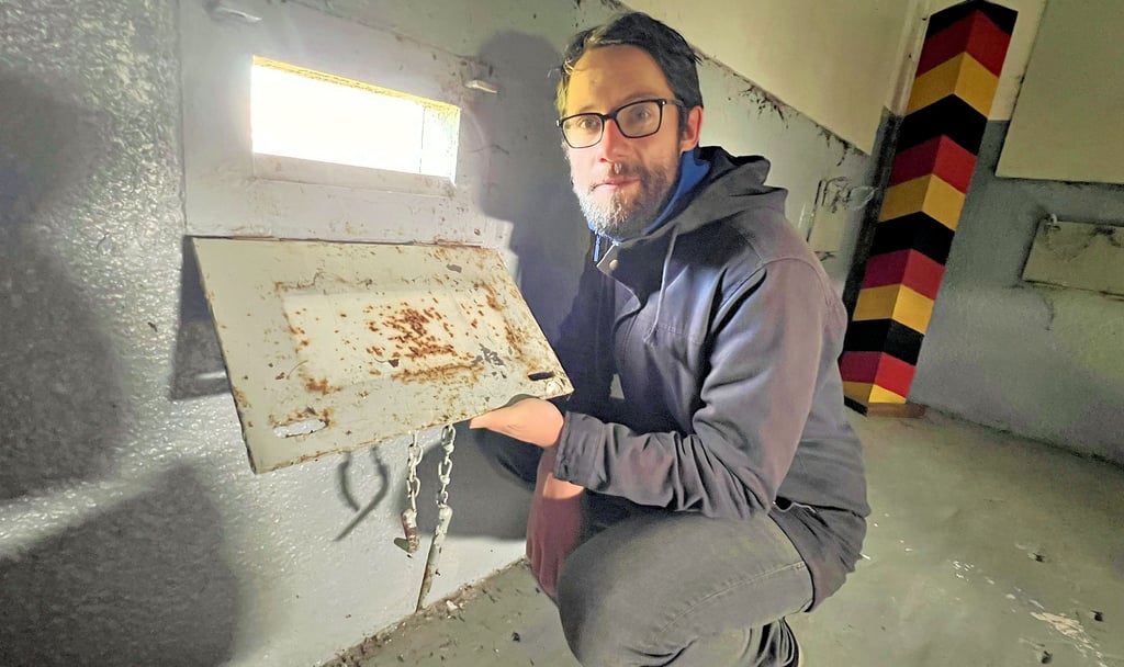 Hauke Heidenreich vom Landesheimatbund blickt durch einer der Schießscharten im ehemaligen Grenzturm bei Hoyersburg.