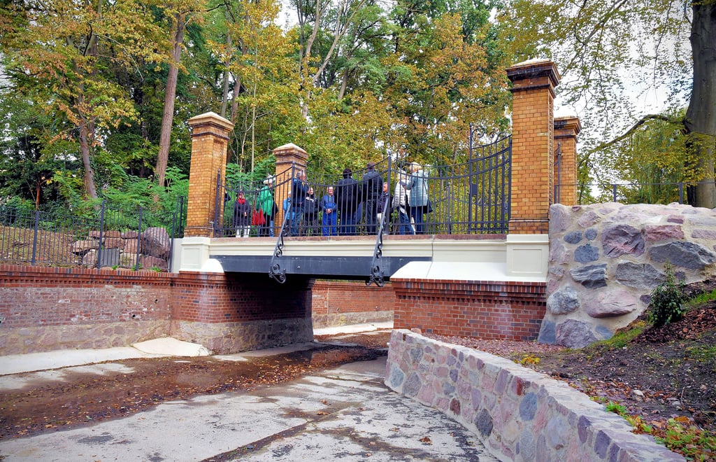 Mitarbeiter von Planungsbüro, Baubetrieb und Stadt sprechen auf der Brücke vor Wittigs Villa über die Wiederinbetriebnahme des Bärteiches.