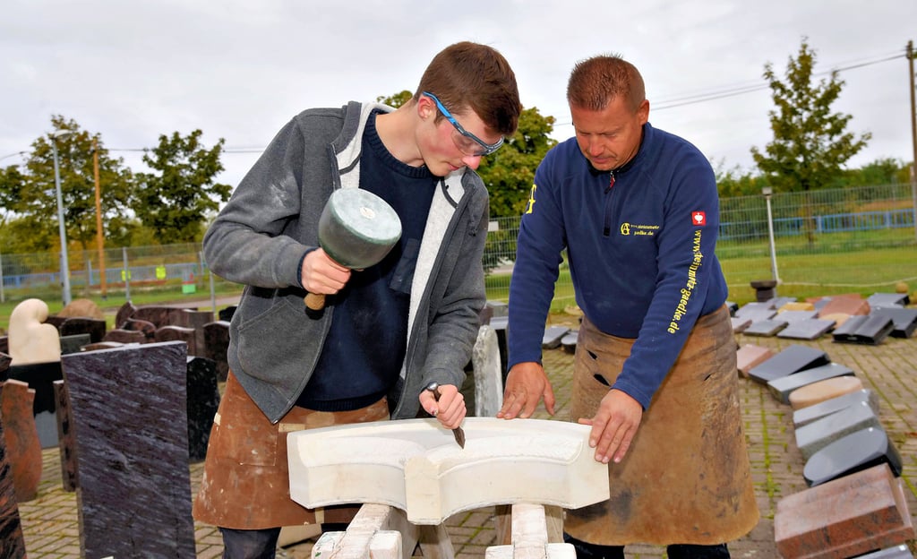 Steinmetzmeister Andreas Gaedke (rechts) und sein Lehrling Denis Wurm arbeiten an einem Übungsstück für die Gesellenprüfung.