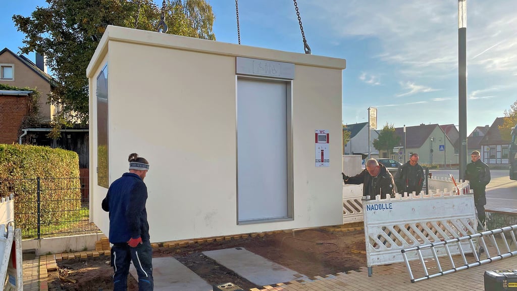 Das neue Klohaus wird von einem Mobilkran auf seinem Platz in der Innenstadt von Osterburg gehievt.