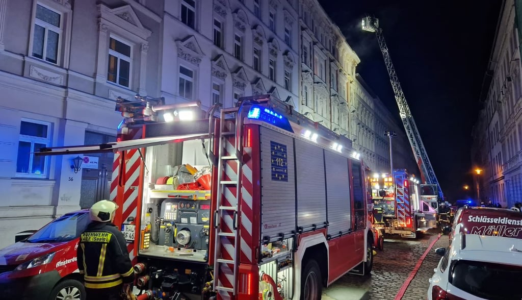 Feuer in Wohnhaus in Halle: Aus den oberen Fenstern eines Mehrfamilienhauses in Halle treten Rauschwaden aus. . Die Feuerwehr rettete Menschen mit einer Drehleiter.