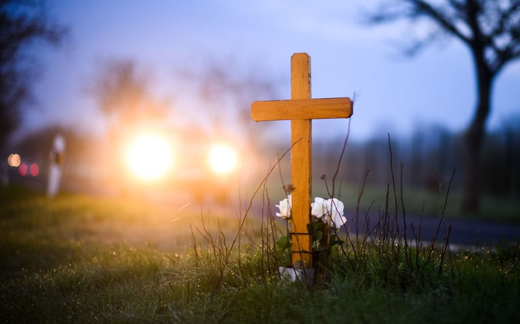 Ein Kreuz und Blumen zum Gedenken an ein 21-jähriges Opfer eines Verkehrsunfalls im Landkreis Hildesheim.