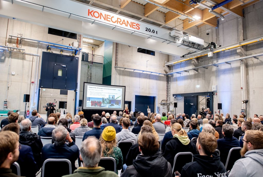 Mitarbeiterinnen und Mitarbeiter des Alfred-Wegener-Instituts sitzen in einer Halle des neuen Technikums.
