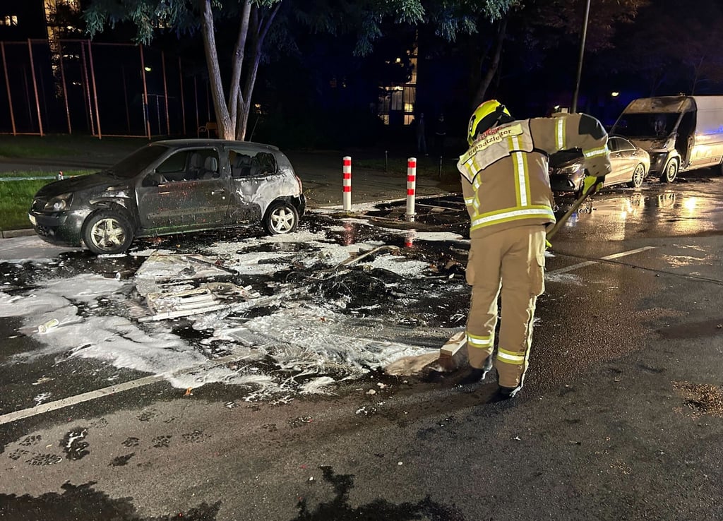 Ein Feuerwehrmann arbeitet an einem Einsatzort auf der Sonnenallee, an dem mehrere Autos in Brand standen.