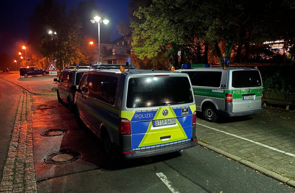 Polizeifahrzeuge stehen vor der Gesamtschule in Hollfeld im Landkreis Bayreuth.