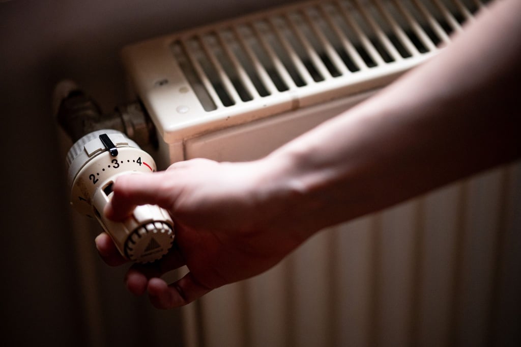 Eine Person benutzt einen Heizkörper in einer Berliner Altbauwohnung.