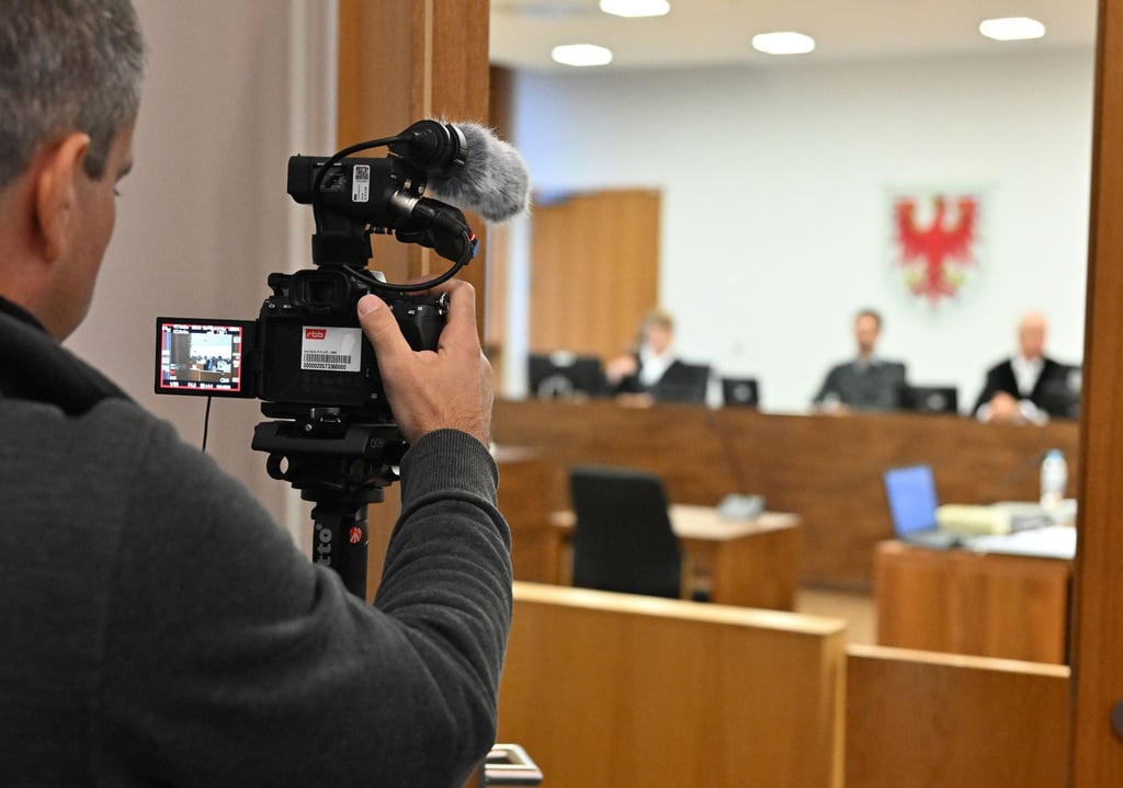 Ein Video-Journalist filmt im Landgericht die sich schließende Tür des Saals, in dem der Prozess wegen illegalen Medikamentenhandel stattfindet.