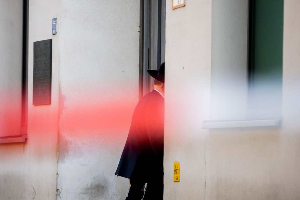 Ein Mann betritt hinter Polizeiabsperrband die jüdische Gemeinde Kahal Adass Jisroel in Berlin-Mitte.