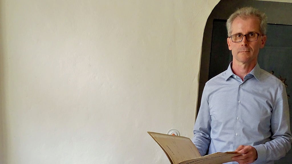 Jörg Mayer von der Stadtkirchengemeinde mit den Zöglingsakten des Glöcknerstifts.
