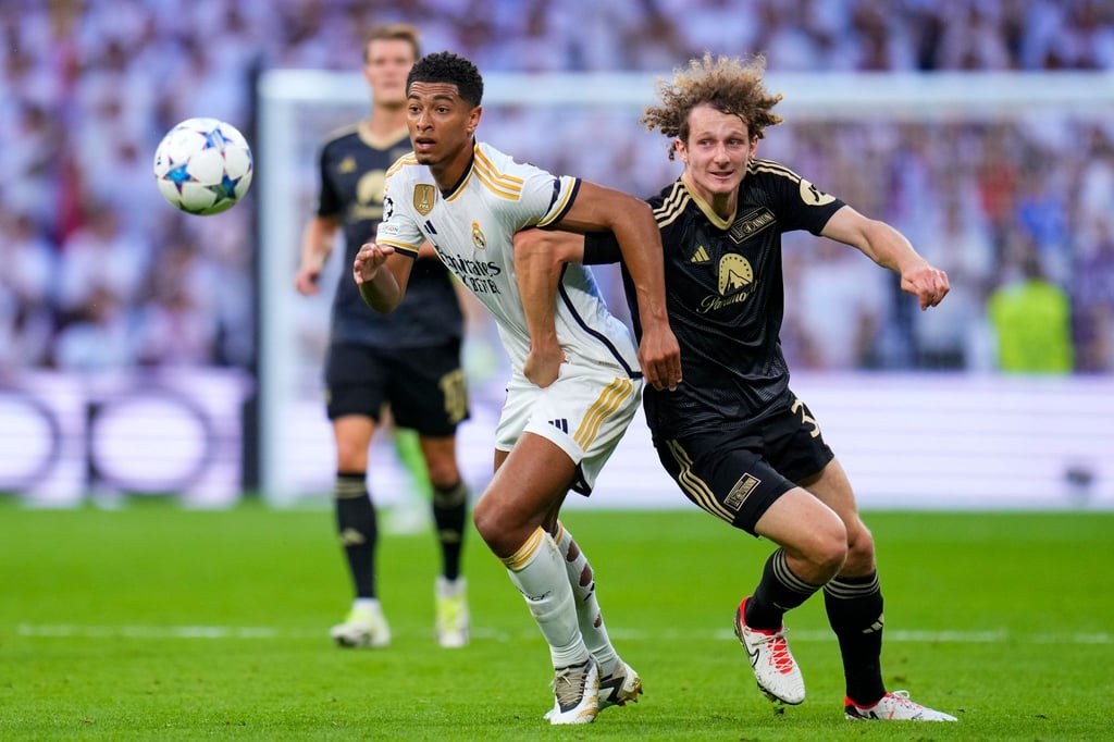 Real Madrids Jude Bellingham (l) und Unions Alex Kral im Zweikampf.