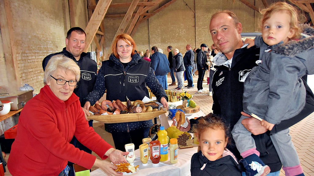 Heike, Christoph und Jana Sue (v.l.) bieten auf dem Regionalmarkt die Produkte von ihrem Schaf- und Geflügelhof in Eickendorf an und erklären: „Unsere Tiere haben reichlich Auslauf, Tageslicht und einen würdigen Umgang“. Von den Köstlichkeiten probieren Michael Lippert und seine Töchter Malu und Jella.