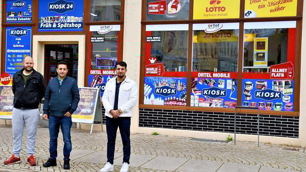 Mitarbeiter Andreas Lange, Inhaber Naji Gado und sein Verwandter Rabeh Ali Gado (von links) vor dem „Kiosk 24“ am Haldensleber Marktplatz.