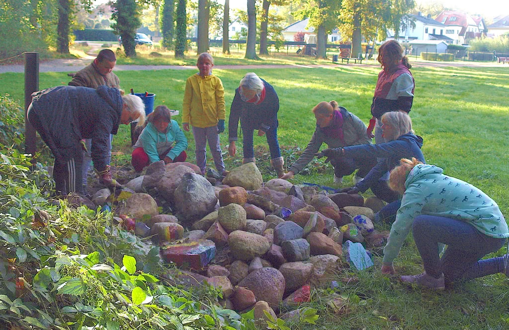 Zusammen mit den Kindern der DRK-Tagesgruppe räumten Anja Grabowski (links), Kathrin Goyer (Mitte) und Birgit Muhl (Zweite von rechts) vom Verein Rund um den See den steinernen Eidechsenhügel auf der Bleiche auf.